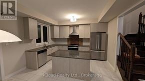 Ajax (South East) townhouse for rent - A modern kitchen with a central island and stainless steel appliances.