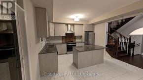 Ajax (South East) townhouse for rent - A modern kitchen with a refrigerator, sink, and stove.