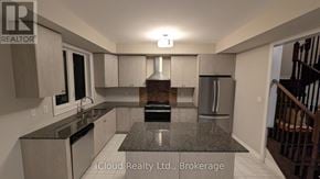 Ajax (South East) townhouse for rent - A modern kitchen with granite countertops and stainless steel appliances.