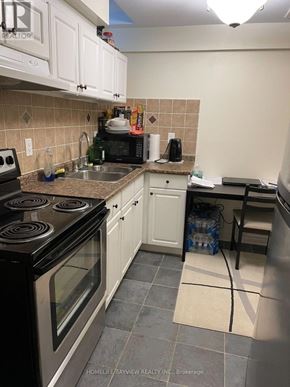 Newmarket (Woodland Hill) apartment for rent - A kitchen with a black stove top oven and white cabinets.