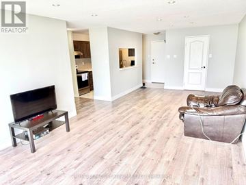 Mississauga (City Centre) condo for rent - A living room with a brown leather chair and a wooden floor.