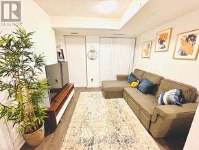 Toronto (Mimico) condo for rent - A living room with a couch, a potted plant, and pictures on the wall.