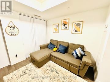 Toronto (Mimico) condo for rent - A tan couch with blue and white pillows in a living room.