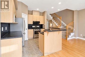 Ottawa townhouse for rent - A kitchen with a refrigerator, stove, and cabinets.