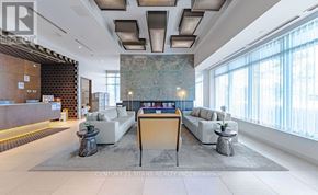 Toronto (Don Valley Village) condo for rent - A spacious living room with a large marble backdrop and a wooden door.