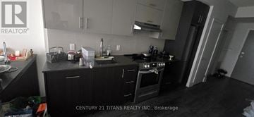 Toronto (Don Valley Village) condo for rent - A kitchen with black cabinets and a stove top oven.