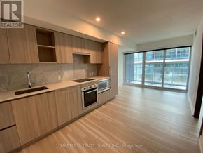 Toronto (Waterfront Communities) condo for rent - A kitchen with wooden cabinets and a large window.
