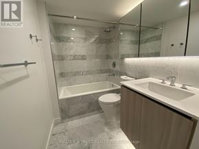 Toronto (Waterfront Communities) condo for rent - A bathroom with a marble tile shower and a toilet.
