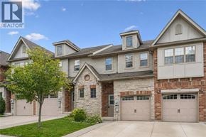 Guelph townhouse for rent - A large, well-maintained house with a stone facade and multiple garages.
