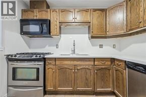 Guelph townhouse for rent - A kitchen with wooden cabinets and a stove top oven.