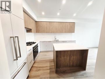 Coquitlam apartment for rent - A modern kitchen with white appliances and wooden accents.