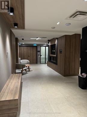 Oakville (Jm Joshua Meadows) condo for rent - A hallway with a bench, chairs, and a door.