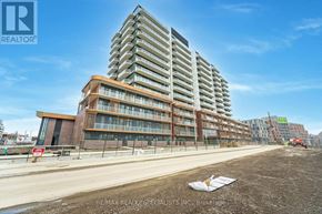 Mississauga (Port Credit) condo for rent - A large, modern building under construction with a clear blue sky in the background.