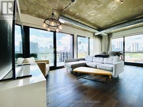 Toronto (Waterfront Communities) condo for rent - A modern living room with a large window overlooking the city.
