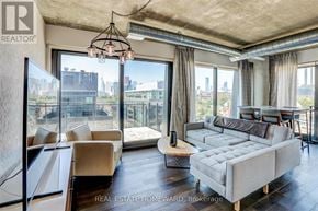 Toronto (Waterfront Communities) condo for rent - A living room with a large window overlooking a cityscape.