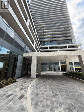 Vaughan (Concord) condo for rent - A modern building with a glass entrance and a stone pillar.