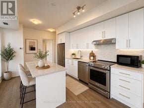 Vaughan (Concord) condo for rent - A modern kitchen with white cabinets and stainless steel appliances.