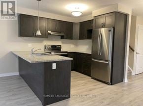 Kitchener townhouse for rent - A kitchen with a granite countertop and stainless steel appliances.