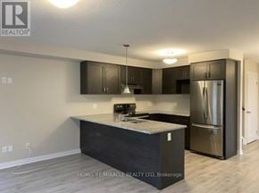 Kitchener townhouse for rent - A kitchen with a refrigerator, cabinets, and a countertop.