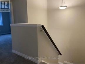 Kitchener townhouse for rent - A staircase with a white wall and a light hanging from the ceiling.