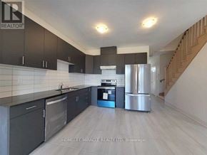 Zorra (Thamesford) townhouse for rent - A kitchen with dark cabinets and stainless steel appliances.
