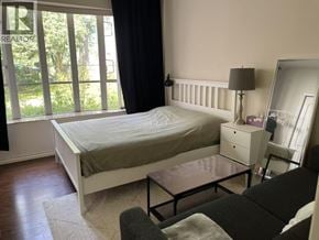 Richmond apartment for rent - A bedroom with a bed, nightstand, and chair.