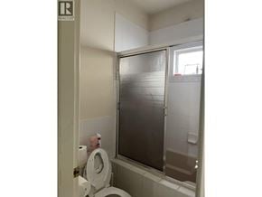Richmond apartment for rent - A bathroom with a toilet and a glass shower door.