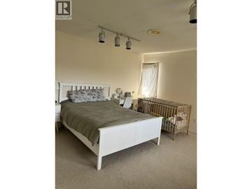Richmond apartment for rent - A bedroom with a white bed and a grey carpet.