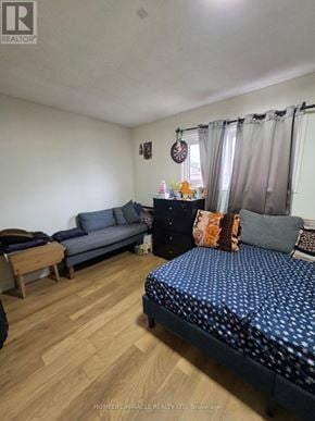 Toronto (Malvern) apartment for rent - A bedroom with a bed, couch, and a wooden table.