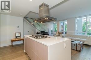 North Vancouver townhouse for rent - A modern kitchen with a stove top oven and a stainless steel range hood.