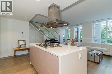 North Vancouver townhouse for rent - A modern kitchen with a stove top oven and a stainless steel range hood.