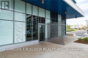 Mississauga (Central Erin Mills) condo for rent - The front of a building with glass doors and windows, with the number 2560 on the glass.
