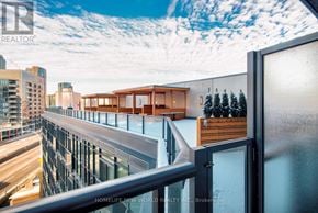 Toronto (Waterfront Communities) condo for rent - A balcony with a glass railing and a view of the city.