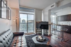 Toronto (Waterfront Communities) condo for rent - A modern living room with a leather sofa and a flat screen TV.