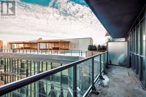 Toronto (Waterfront Communities) condo for rent - A modern building with a glass balcony overlooking a snowy landscape.