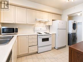 Toronto (Woburn) condo for rent - A kitchen with white appliances and wooden cabinets.