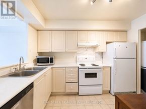 Toronto (Woburn) condo for rent - A kitchen with white appliances and cabinets.