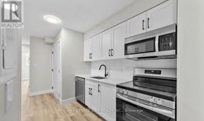 London South (South J) multi-family for rent - A kitchen with white cabinets and appliances is on the market.