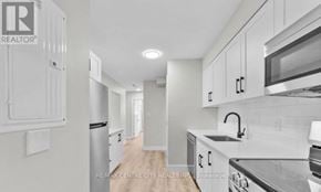 London South (South J) multi-family for rent - A kitchen with white cabinets and a stainless steel refrigerator.