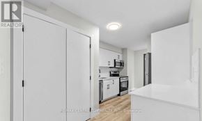 London South (South J) multi-family for rent - A white kitchen with a refrigerator, microwave, oven, and cabinets.