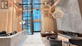 Toronto (Church-Yonge Corridor) condo for rent - A modern office lobby with a reception desk and a view of the outside through a large window.