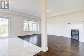New Tecumseth (Alliston) apartment for rent - A spacious living room with a fireplace and hardwood floors.