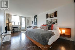 Toronto (Cabbagetown-South St. James Town) condo for rent - A bedroom with a large bed and a desk with a lamp.
