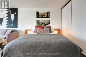 Toronto (Cabbagetown-South St. James Town) condo for rent - A bedroom with a large bed and a painting of a deer skull on the wall.