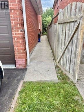 Mississauga (Hurontario) apartment for rent - A wooden fence runs along the side of a brick building.