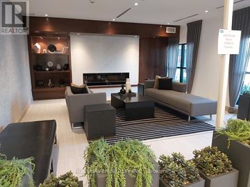 Oakville (Go Glenorchy) condo for rent - A modern living room with a black sofa and a wooden coffee table.