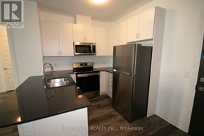 Oakville (Go Glenorchy) condo for rent - A kitchen with a refrigerator, microwave, and oven.
