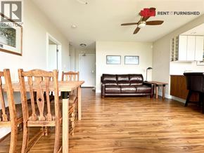 Vancouver apartment for rent - A living room with a brown leather couch and wooden chairs.