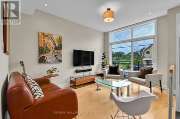 Ottawa apartment for rent - A living room with a brown leather couch and a glass coffee table.
