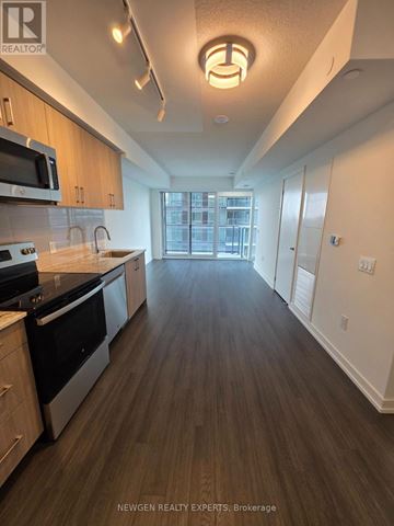 Toronto (Humber Heights) condo for rent - A kitchen with wood floors and a large window.